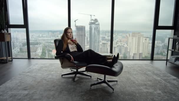 Geschäftsfrau entspannt sich auf Stuhl im Büro. Frau riecht Weinduft im Glas - Filmmaterial, Video