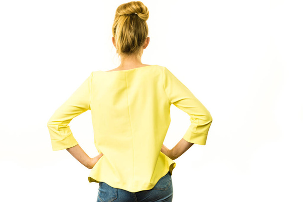 Adult woman presenting her casual beautiful outfit, long sleeved yellow top from back. - Foto, afbeelding