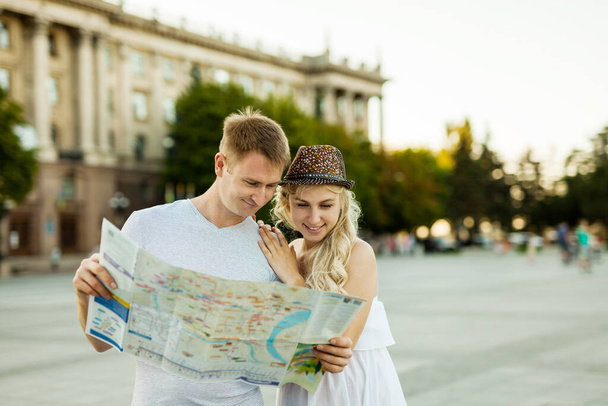 vacaciones de verano, citas y concepto de turismo - pareja sonriente en gafas de sol con mapa en la ciudad - Foto, imagen