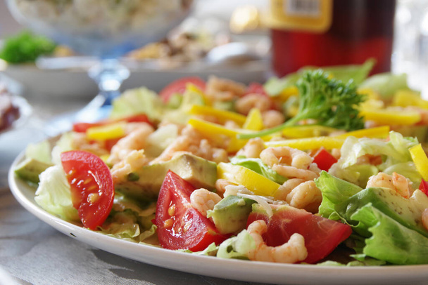 Salad with shrimp on a festive table. Shrimp salad. Closeup - Фото, зображення