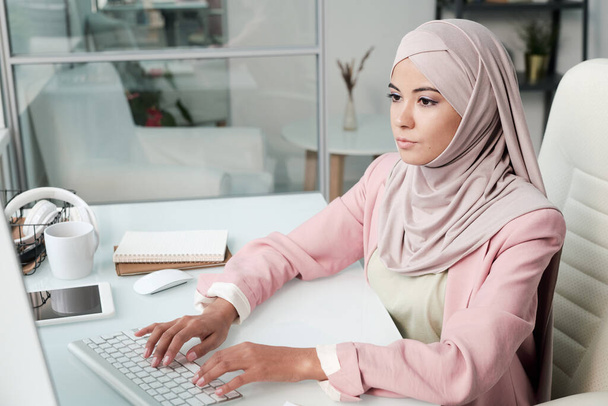 Mujer musulmana trabajando en la computadora portátil en la oficina moderna - Foto, imagen