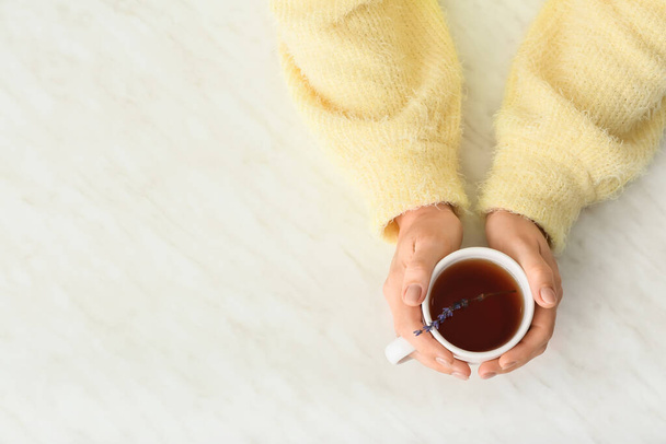 Nő csésze forró tea az asztalnál - Fotó, kép