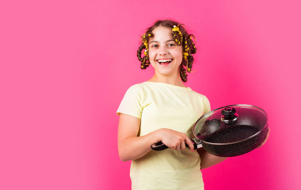 Shop home utensils. Kitchen accessories. Culinary and house duties. Stereotype housewife style. Small girl with curlers in hair. Girl hold Frying Pan. Little kid hold pan cooking meal. Pin up style - Photo, Image