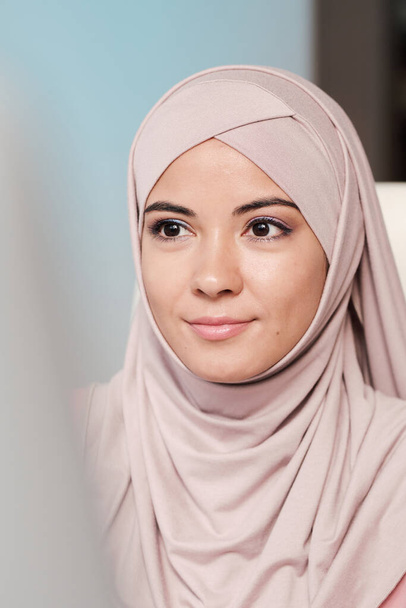 Портрет молодой привлекательной мусульманки в хиджабе, звонящей по телефону своей подруге - Фото, изображение