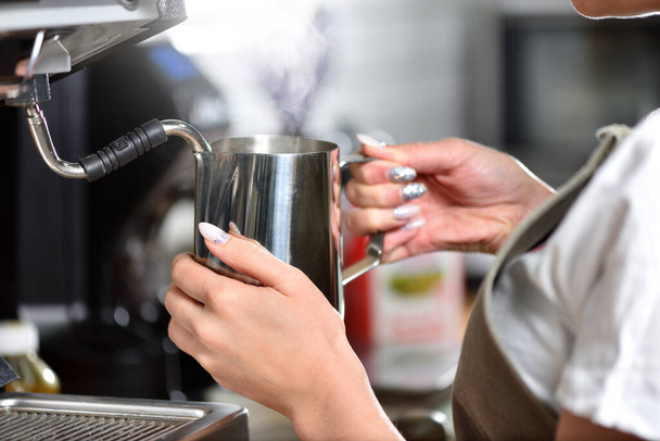 Young girl barista makes coffee on a large professional coffee machine, hands closeup. The concept of a small business and work for a student. - Fotoğraf, Görsel