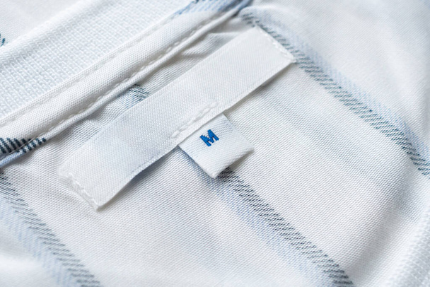 Yeni gömlekte boş beyaz giysi etiketi - Fotoğraf, Görsel