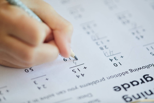 Primer plano extremo de un niño irreconocible haciendo un examen de matemáticas para la escuela en línea mientras estudia en casa, copia el espacio - Foto, Imagen