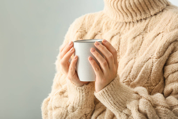 Mujer con taza de té caliente sobre fondo claro - Foto, imagen