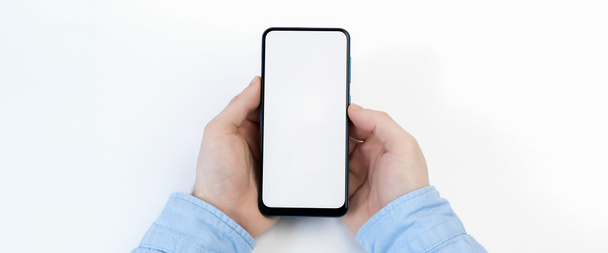 Mãos masculinas segurando smartphone com tela em branco no fundo branco
 - Foto, Imagem