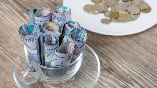 Kazakstan tenge on Cup ja lautasella pöydällä.Paljon Kazakstanin rahaa.Sahaamalla budjetin, toimeentulon minimi tai kahden valuutan kori Kazakstanissa.Kriisi lasku valuuttakurssit - Valokuva, kuva