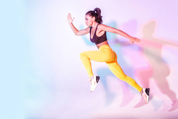Beautiful fit woman making sport and running. Studio gel lighting - Foto, Imagem