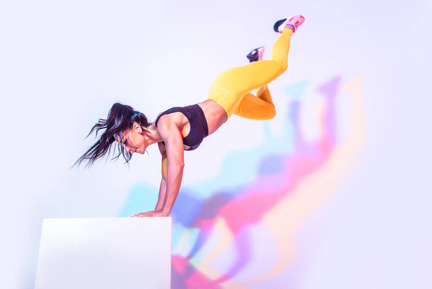 Beautiful woman training at home making exercizes on the workout box - Foto, imagen