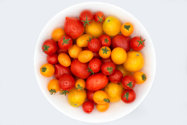 mix of bright ripe and juicy yellow and red tomatoes on a white background - Foto, Bild