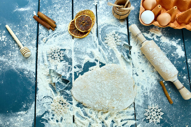 Christmas baking background. Raw dough for Christmas cookies. Kitchen utensils and ingredients for cooking baking - Photo, image