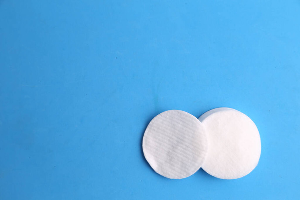 A top view of cotton discs on a blue surface under the lights - Φωτογραφία, εικόνα