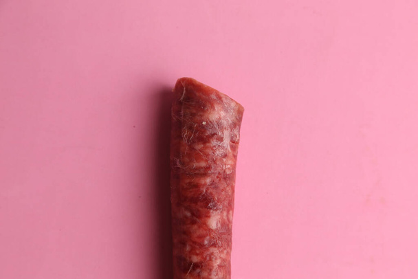 A closeup shot of chorizo sausage on pink background - Фото, зображення
