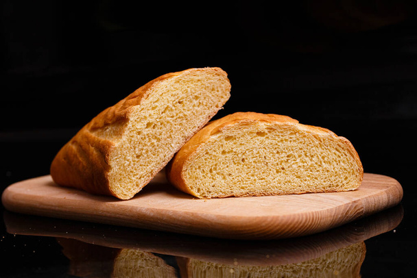 Σπιτικό ψωμί. Ψήσιμο στο σπίτι. Ψωμί στρογγυλό σε ξύλινη σανίδα. - Φωτογραφία, εικόνα