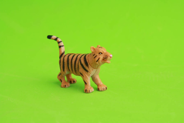 A small tiger toy on a green background - Fotografie, Obrázek