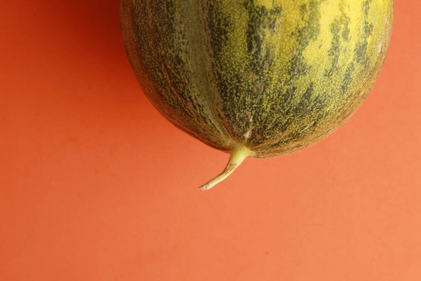 A closeup shot of whole melon on a colored background - Foto, afbeelding