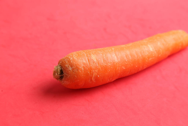 A closeup shot of carrot isolated on a red background - Foto, imagen