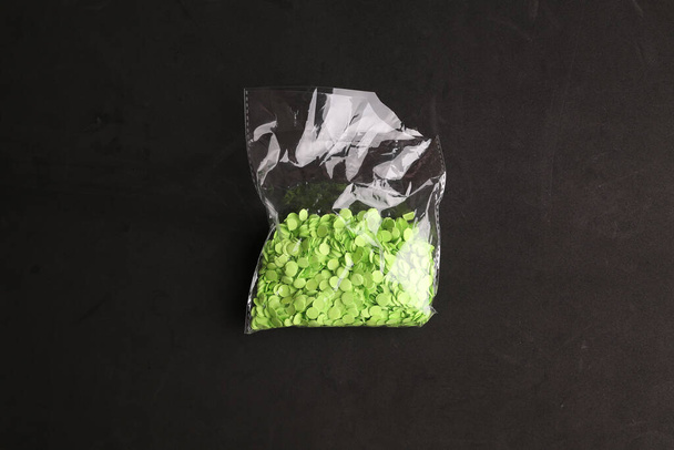 A closeup shot of frozen greens in a bag on black background - Фото, изображение