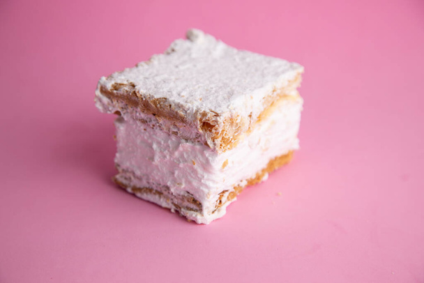 A closeup shot of a piece of cookie biscuits filled with cream isolated on a pink surface - Fotoğraf, Görsel