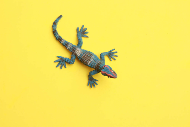 A rubber lizard toy isolated on yellow background - Фото, зображення