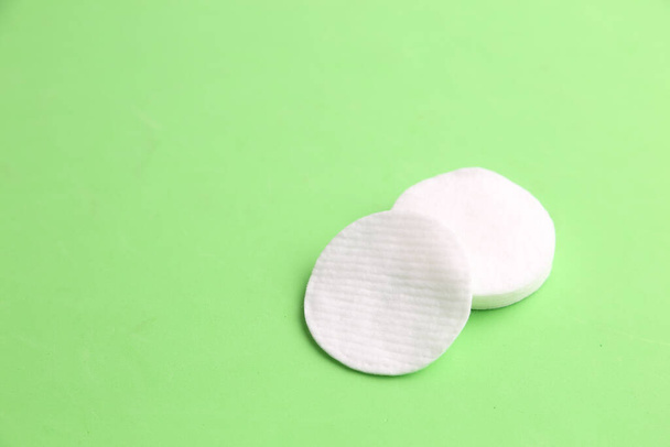 A closeup shot of the round cotton discs on a green background - Foto, imagen