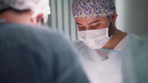 Artsen leveren anesthesie aan de chirurgische patiënt in de operatiekamer. Actie. Close-up van artsen die de ingreep uitvoeren en de patiënt voorbereiden op de ingreep. - Video