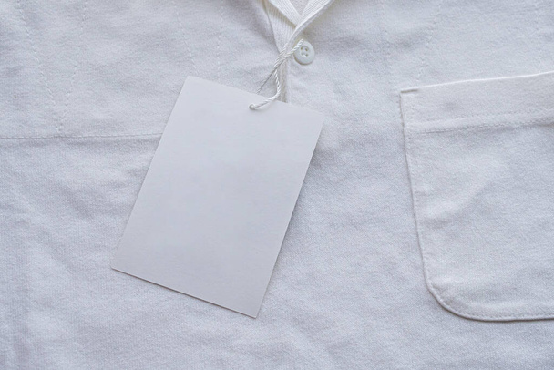 Yeni gömlekte boş beyaz kıyafet etiketi etiketi - Fotoğraf, Görsel
