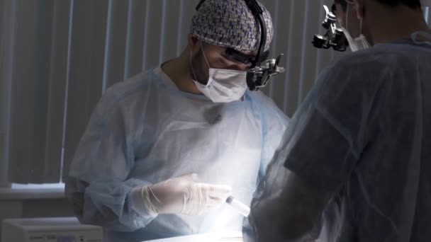 I medici consegnano l'anestesia al paziente chirurgico in sala operatoria. Azione. Primo piano dei medici che eseguono l'operazione e preparano il paziente alla procedura. - Filmati, video