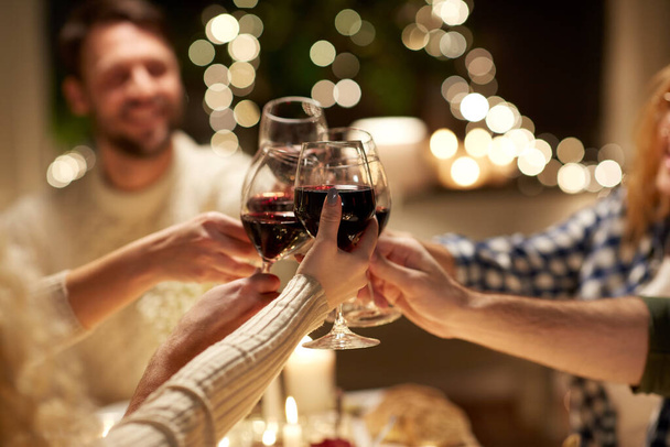 onnellisia ystäviä juo punaviiniä joulujuhlissa - Valokuva, kuva