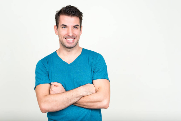 Studio shot of young handsome Hispanic man against white background - Foto, afbeelding