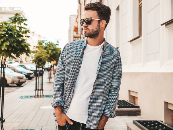 Portrait of handsome confident stylish hipster lambersexual model.Man dressed in shirt. Fashion male posing on the street background in sunglasses - Φωτογραφία, εικόνα