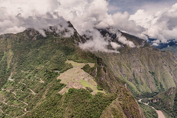 Αεροφωτογραφία από την κορυφή Wayna, Huayna Picchu στο Machu Picchu το συγκρότημα της πόλης Incas και την κορυφή του βουνού Machu Picchu στο βάθος. Βρίσκεται κοντά στο Κούσκο, Περού. - Φωτογραφία, εικόνα