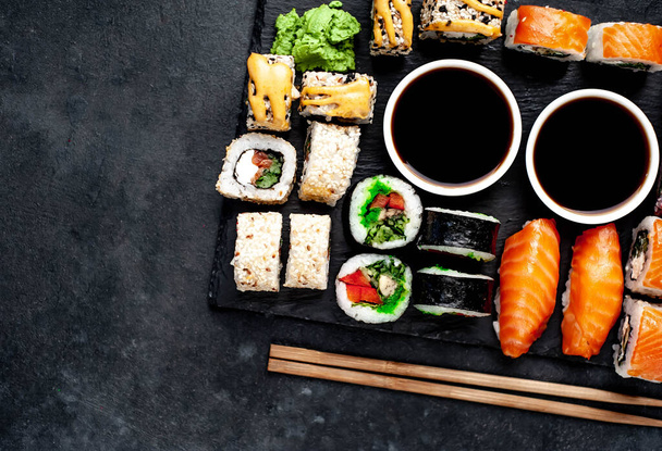 Close up top view foto van diverse sushi set met sojasaus en eetstokjes - Foto, afbeelding