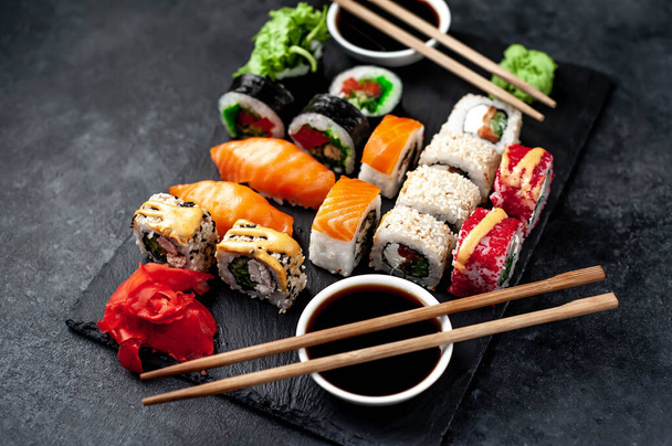 Close up photo of assorted sushi set with soy sauce and chopsticks - Foto, Imagen