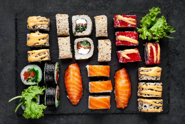 Photo rapprochée de sushis assortis avec sauce soja et baguettes - Photo, image