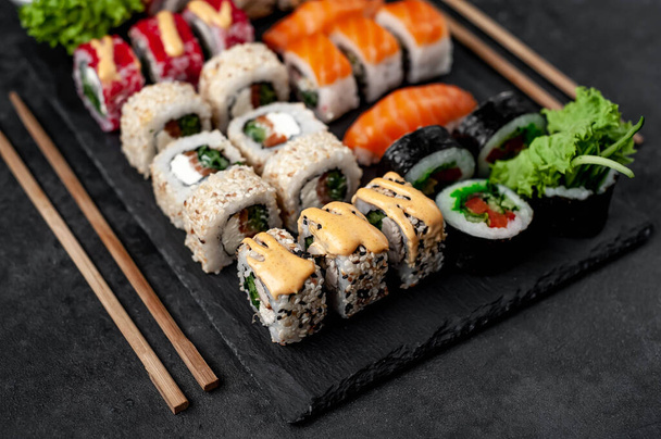 Seitenansicht Nahaufnahme Foto von verschiedenen Sushi-Set mit Sojasauce und Essstäbchen - Foto, Bild