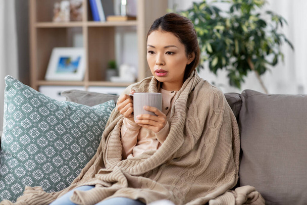 surullinen sairas aasialainen nainen juo kuumaa teetä kotona - Valokuva, kuva