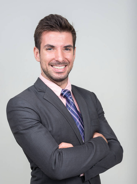 Studio shot of young handsome Hispanic businessman in suit against white background - Zdjęcie, obraz