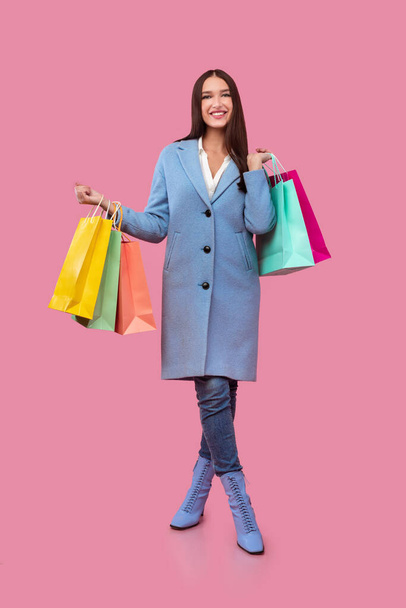 Happy lady holding shopping bags at studio - Фото, изображение