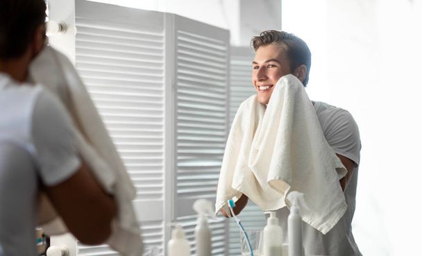 Homem confiante olhando no espelho com toalha
 - Foto, Imagem
