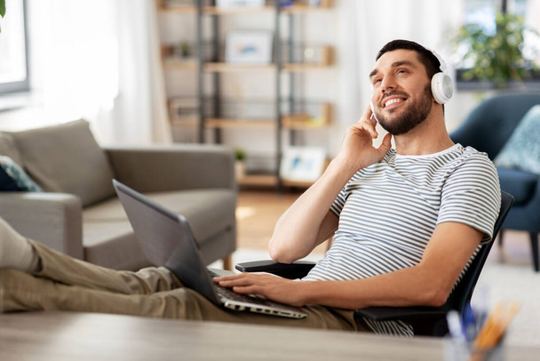 boldog ember laptop és fejhallgató otthon - Fotó, kép