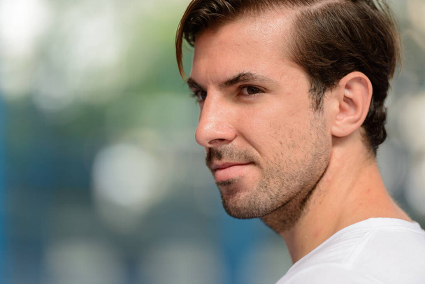 Portrait of young handsome Hispanic man ready to play at the padel court - Photo, Image