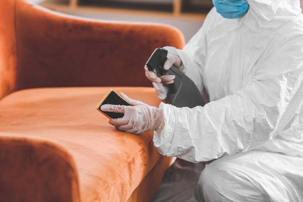 Arbeiter im Biohazard-Kostüm entfernt Schmutz vom Sofa im Haus - Foto, Bild