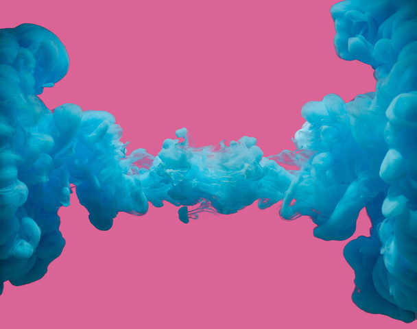 Blue paint abstract underwater smoke against pastel pink background. Room for text. - Photo, Image
