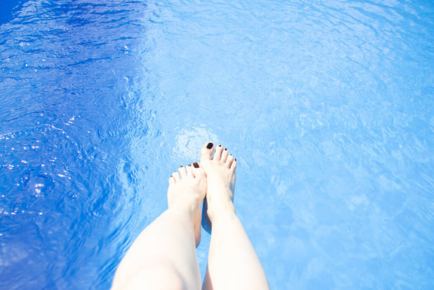 Naisjalat altaan sinisessä vedessä. Kesäloma. Sinisen uima-altaan pinta. Taustaa - Valokuva, kuva