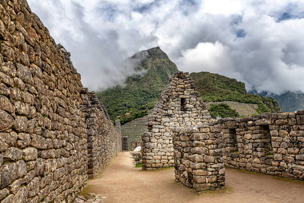 Vue sur les bâtiments et les maisons des structures de l'ancienne ville incas de Machu Picchu près de Cusco au Pérou. Machu Picchu sommet de montagne à l'arrière-plan. - Photo, image