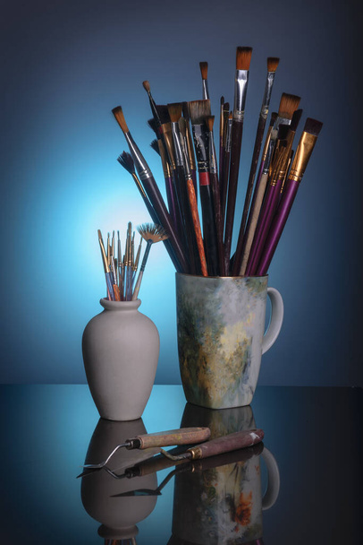 las herramientas del artista - los pinceles y el cuchillo de paleta sobre el fondo oscuro - Foto, imagen
